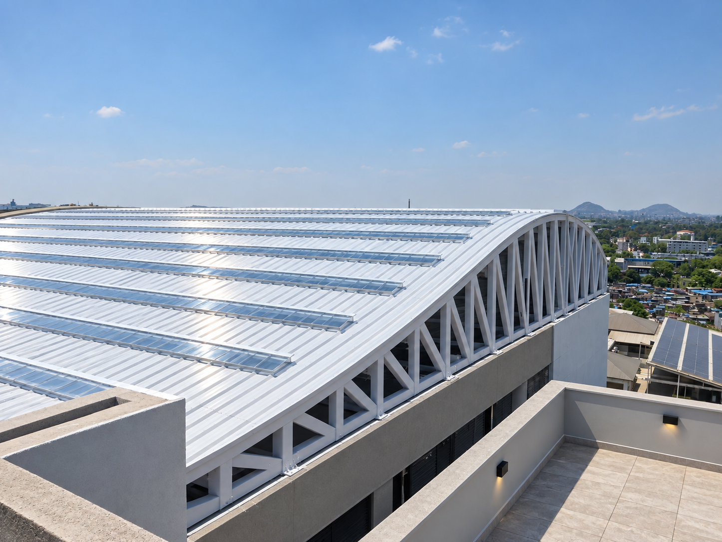 Curved metal roof and white steel trusses above a commercial building
